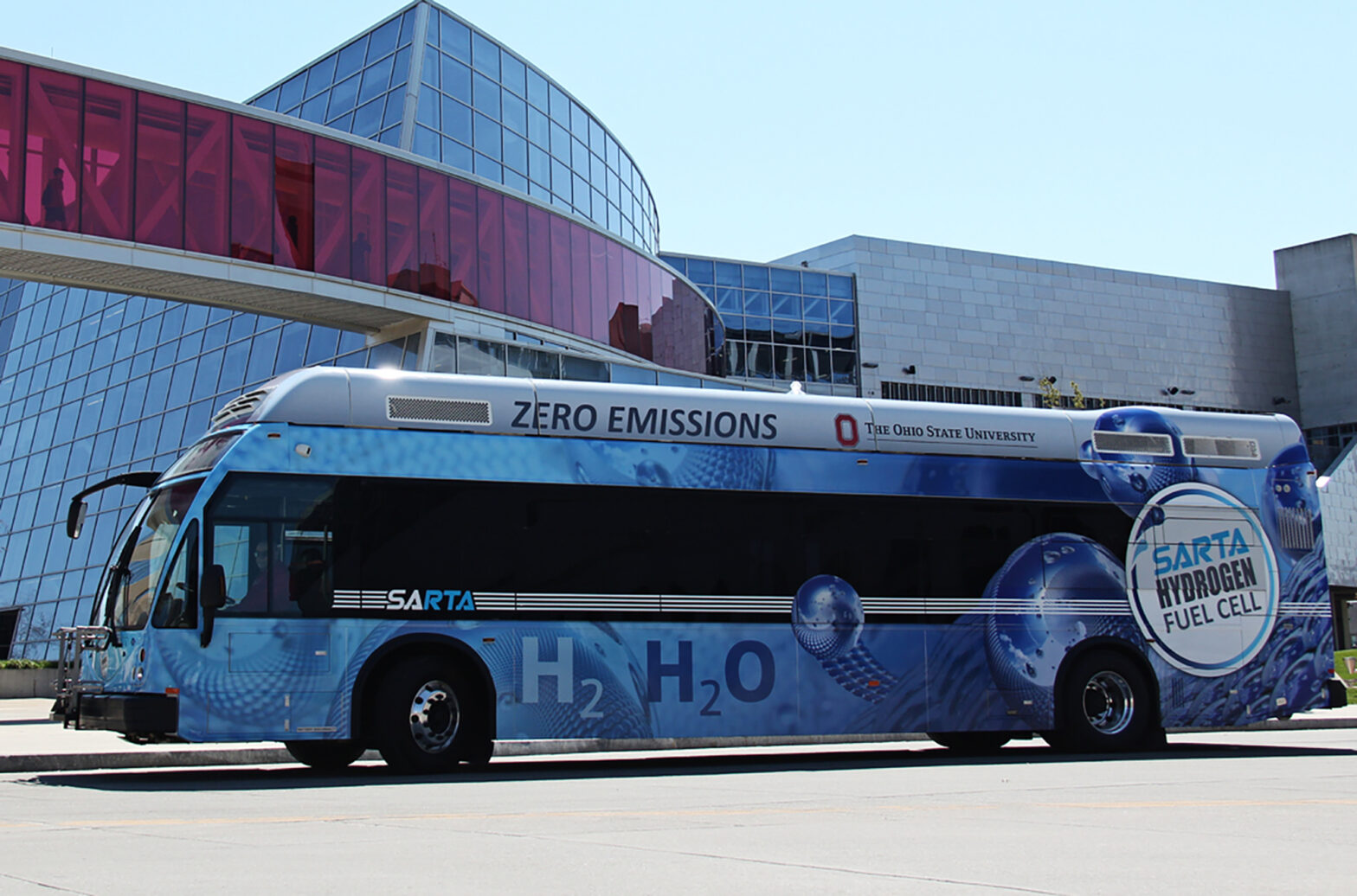 Blue SARTA Hydrogen Fuel Cell bus sitting in front of Building