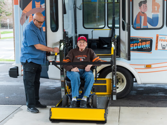Bus Driver helping rider off of Paratransit lift